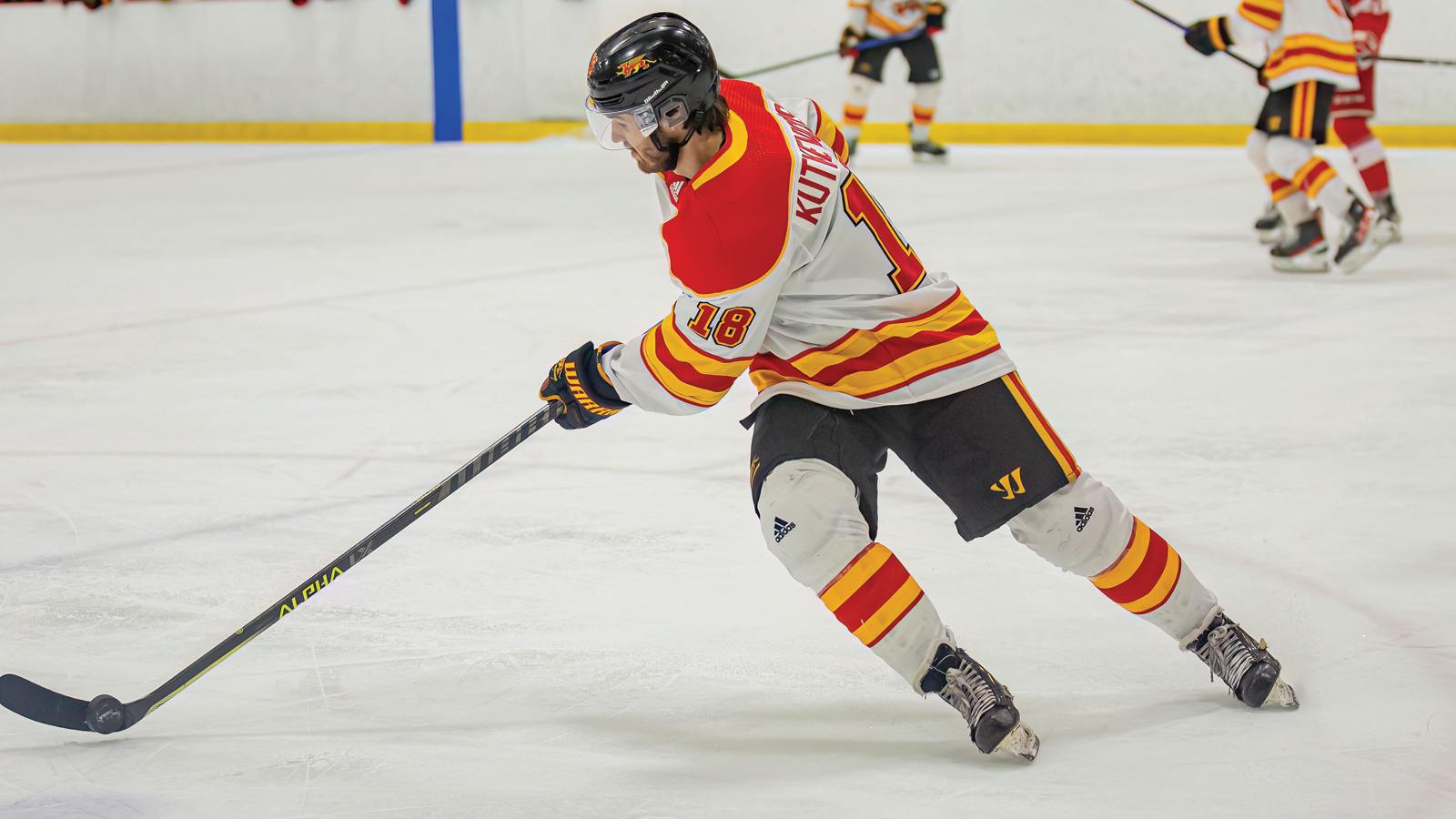 Guelph men's hockey player Luke Kutkevicius skating on the ice with the puck on his stick