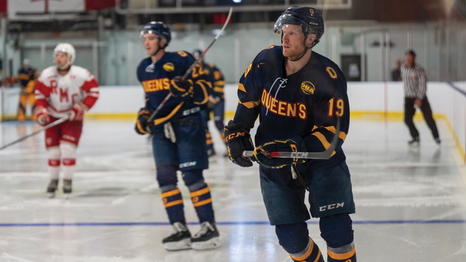 Action photo of Queen's men's hockey player Nolan Hutcheson skating on the ice as part of a pre-game warm-up