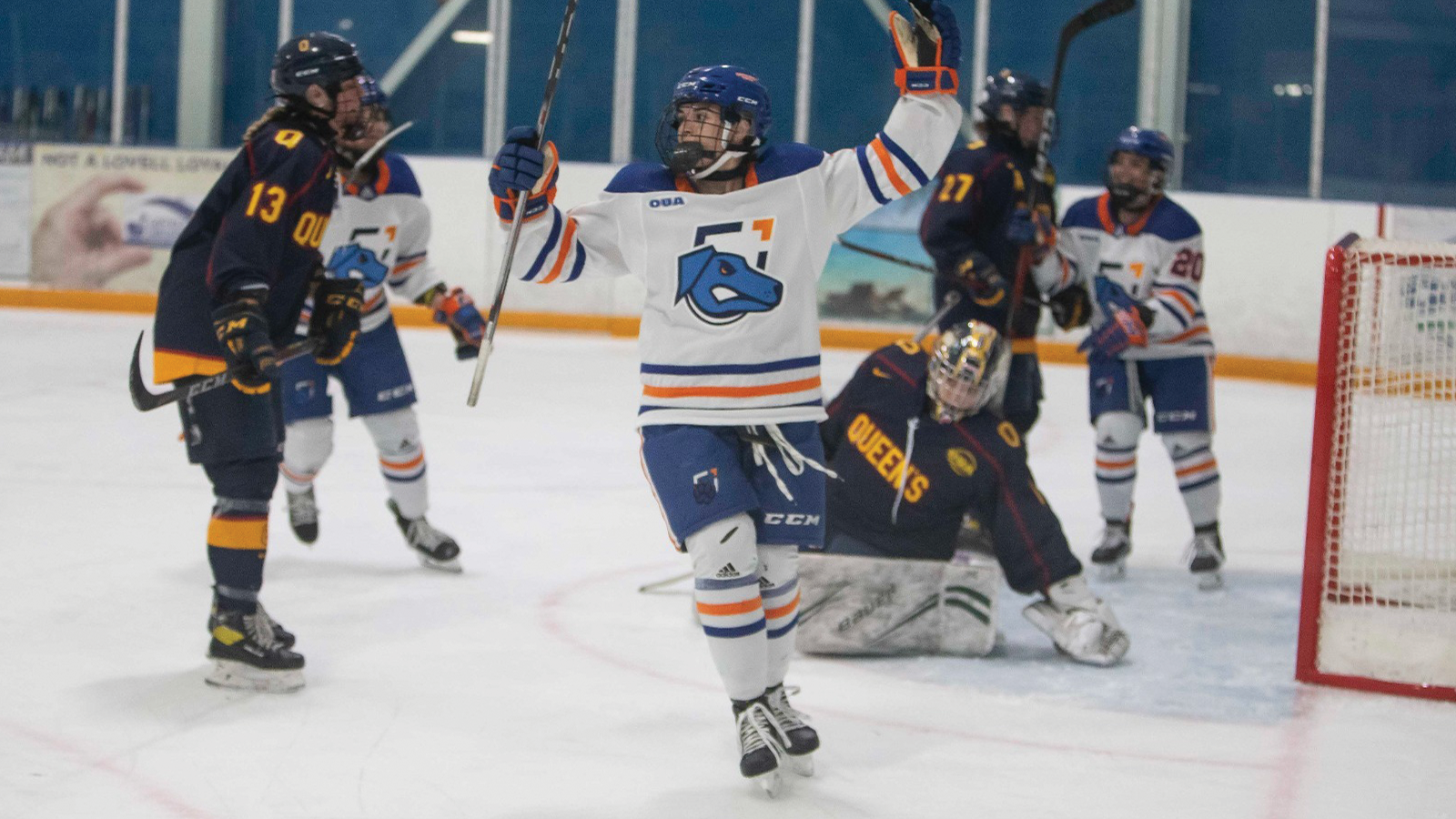 Ontario Tech women's hockey player raising her arms in celebration on the ice after a goal was scored