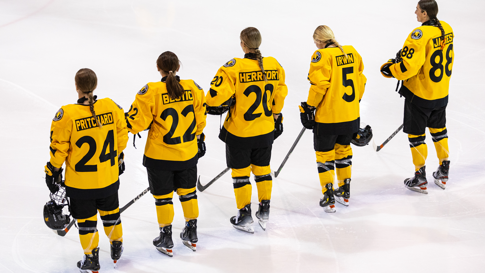 Members of the Waterloo women's hockey team lined up on along the blue line pre-game