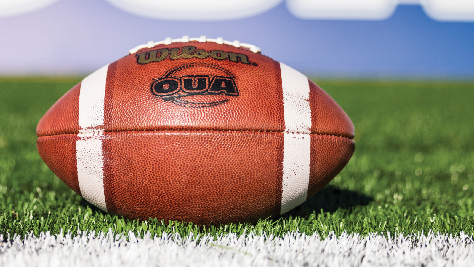 OUA branded football sitting on a football field
