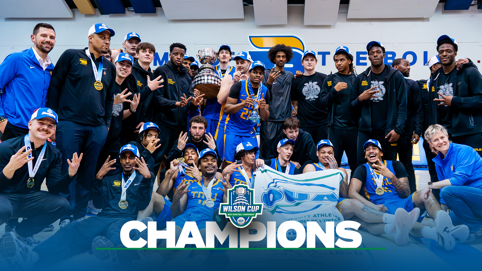 Banner photo of the TMU Bold men's basketball team after winning the OUA Wilson Cup Championship with a blue gradient on the bottom and the OUA Wilson Cup Championship logo and the OUA logo on the bottom and the word Champion in large white letters.  
