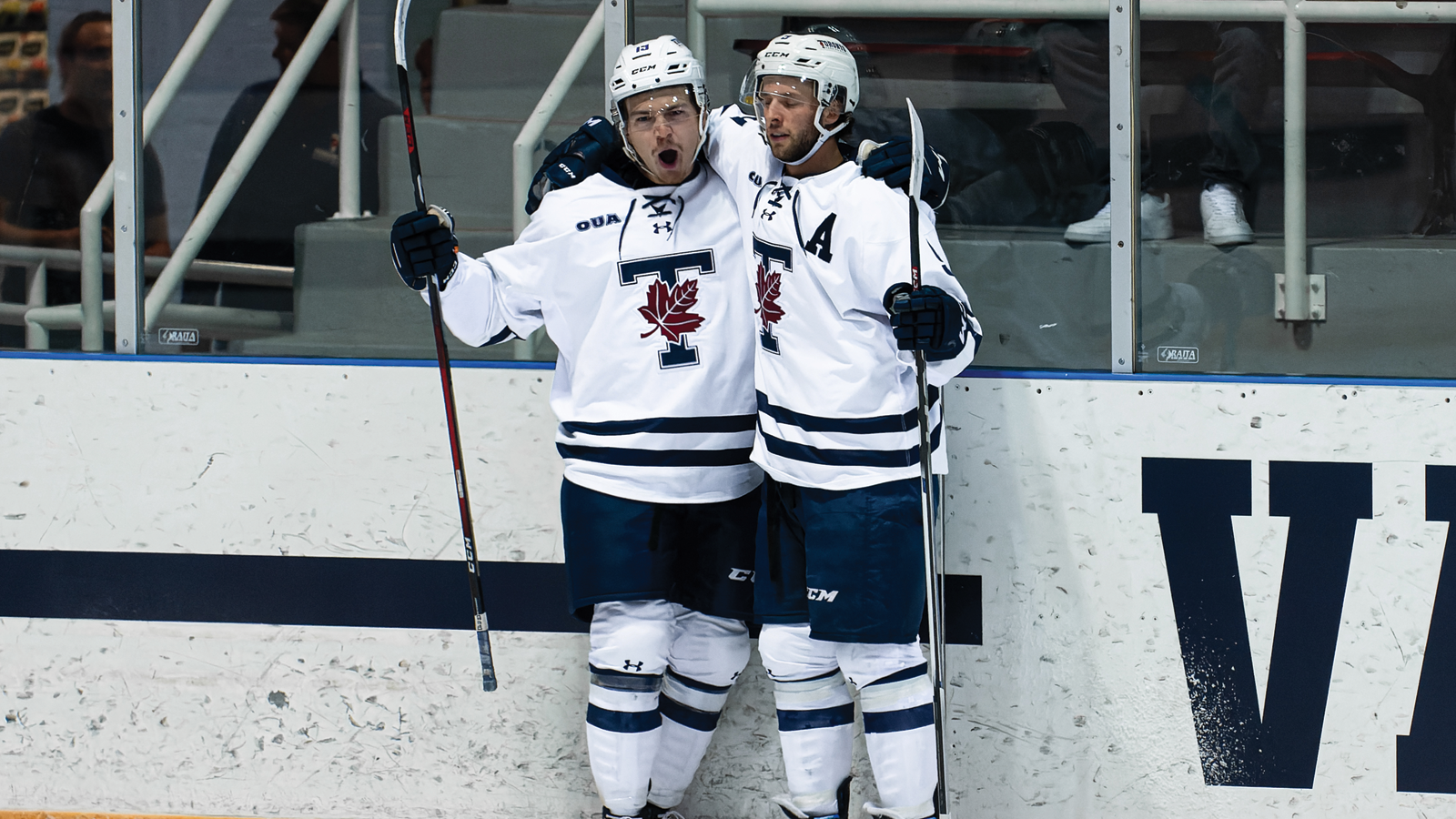 Two Toronto men's hockey players with their arm around the other in celebration of a goal
