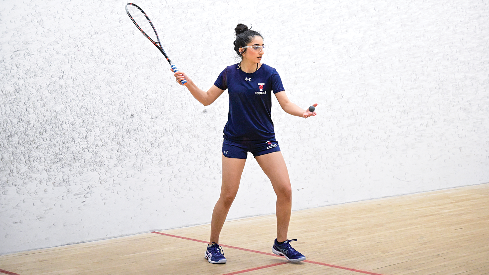 Action photo of a Toronto Varsity Blues women's squash player 